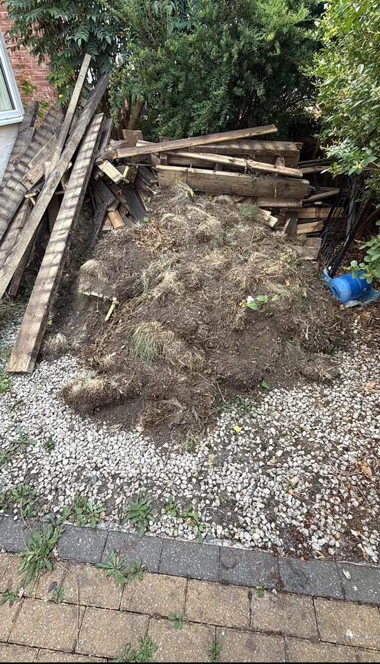 Timber and turf piled beside a house.